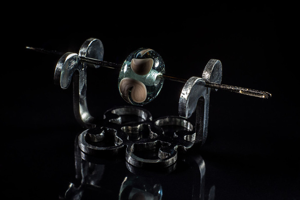 Transparent and grey glassy bead on stand - 写真・画像