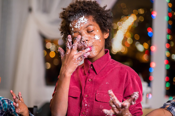 Kid licks cake-smeared fingers. - Photo, Image