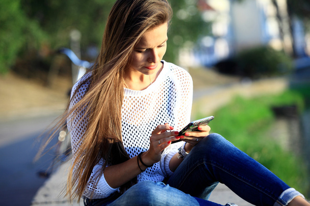 Young beautiful woman with smartphone - outdoor portrait - Zdjęcie, obraz