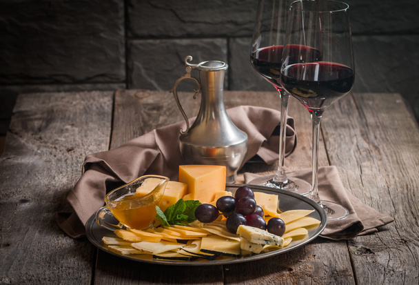 Изысканный натюрморт из красного вина, винограда и сыра
 - Фото, изображение