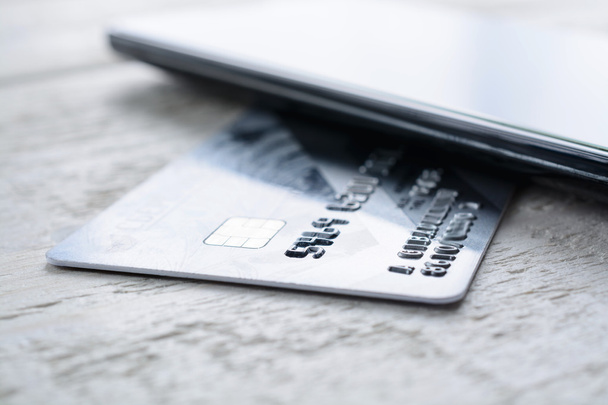 Karty kredytowej i smartphone leżącego na drewnianym stołem - Zdjęcie, obraz