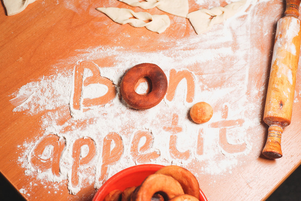 小麦粉とテーブルの上の碑文ボナペティ - 写真・画像