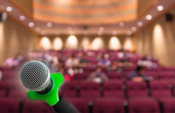 Mikrofon mit abstraktem verschwommenem Foto von Konferenzsaal oder Konferenzraum mit Teilnehmerhintergrund - Foto, Bild