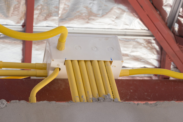 Желтые ПВХ трубы для электрических коробок и проводов, зарытых на конкре
 - Фото, изображение