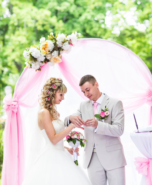 Groom mettre une bague sur le doigt des mariées pendant la cérémonie de mariage
 - Photo, image