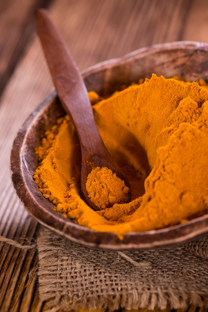 Turmeric and wooden spoon - Foto, afbeelding