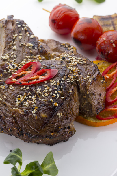 beef steak served with tomatoes and sesame  on a white plate - Foto, Imagen