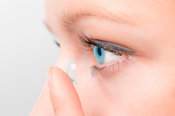 Woman inserting a contact lens in eye. - Photo, Image