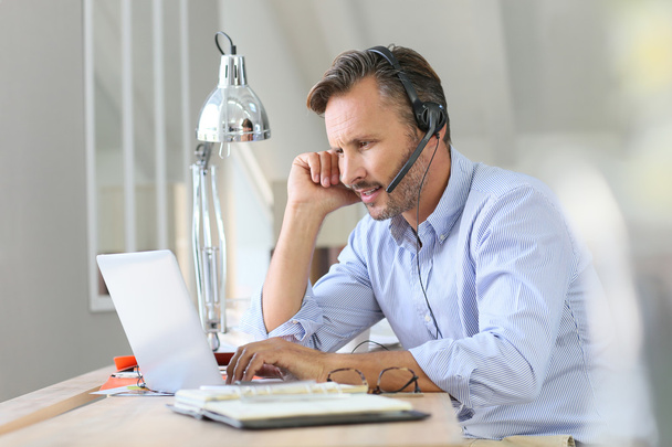 Businessman teleworking with  headset on - Photo, Image