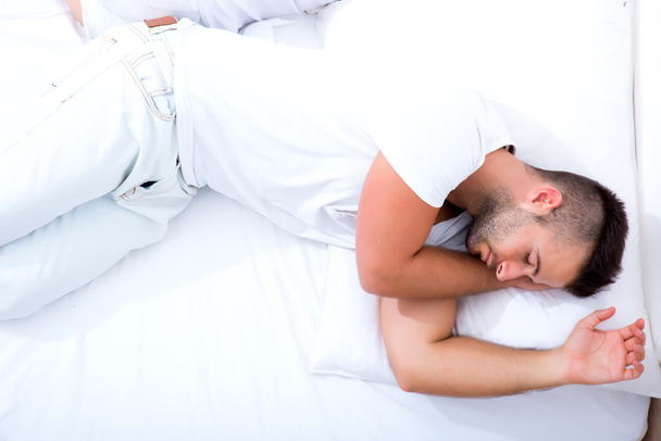 Young man laying in bed 		 - Valokuva, kuva