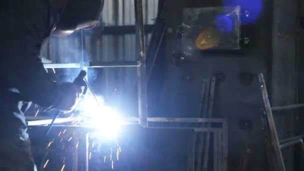 Werken in de fabriek. Elektrische lasser op het werk. Metalen constructie. - Video