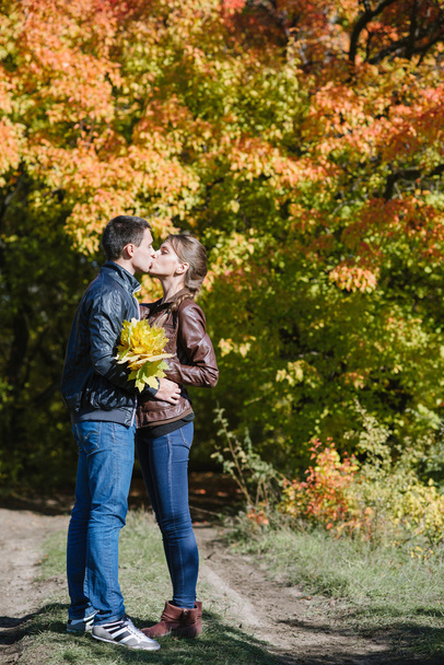 young couple in love, kiss, autumn vivid landscape - Фото, изображение