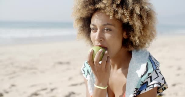 mujer comiendo manzana en la playa
 - Metraje, vídeo