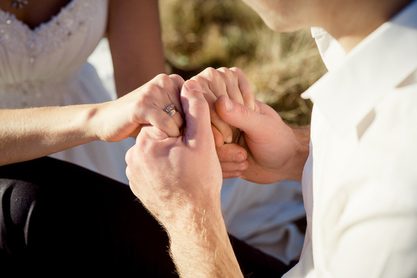 Νύφη και γαμπρός απαλά, κρατώντας τα χέρια κοντινό. Μήνας του μέλιτος - Φωτογραφία, εικόνα