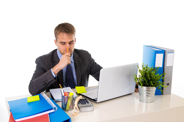 nuori liikemies ylityöllistetty näköinen huolissaan istuu toimistossa tietokone desk stressiä
 - Valokuva, kuva