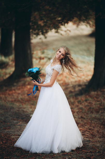 Luxuty portrait of blonde bride with bridal bouquet in autumn - 写真・画像