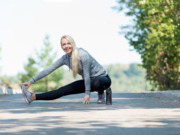 Fitness woman doing streching during outdoor cross training work - Photo, image