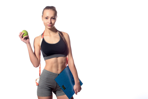 attractive fitness model with measuring tape on a white background - Valokuva, kuva
