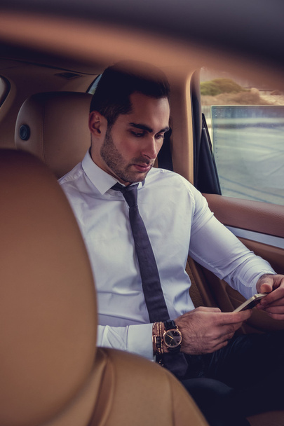 Businessman with smartphone in the car. - Zdjęcie, obraz
