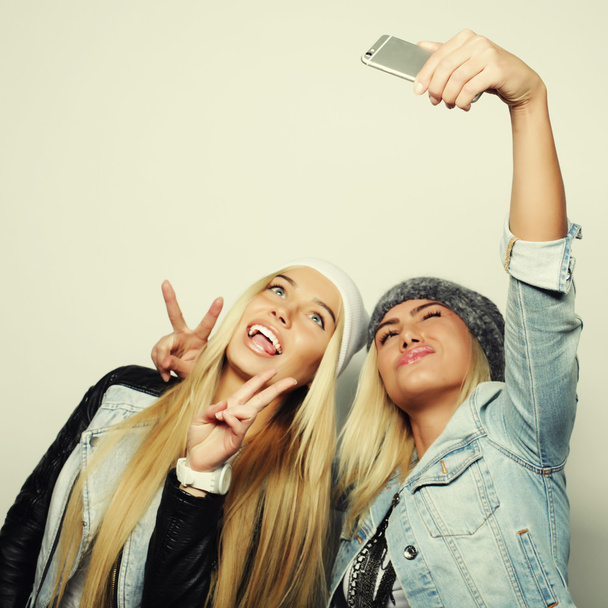 Two teenage girls friends in hipster outfit make selfie - Fotó, kép