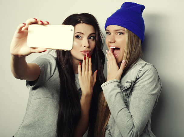 Two teenage girls friends in hipster outfit make selfie - Foto, imagen