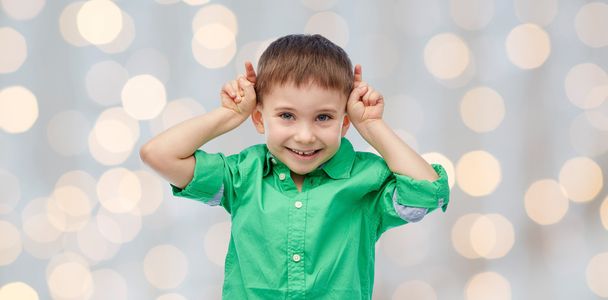 happy little boy having fun and making horns - Фото, изображение