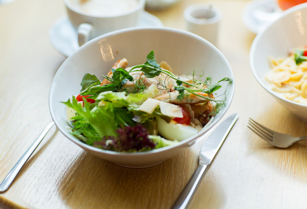 close up of caesar salad on plate at restaurant - Zdjęcie, obraz