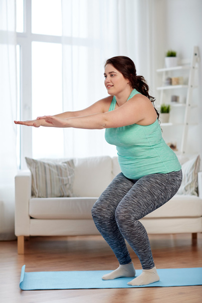 plus size woman exercising on mat at home - Foto, Imagem