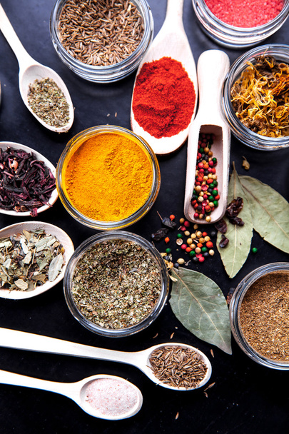 Spices on black background in special jars. Food - Foto, imagen