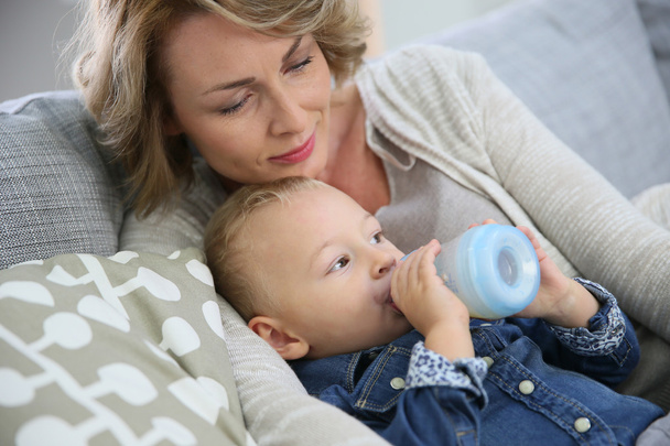 Mommy watching baby boy drinking - Photo, image