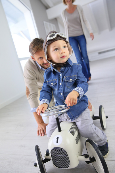 Man helping boy on toy car - Foto, Bild