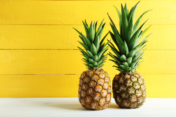 Ripe pineapples on table - Fotoğraf, Görsel