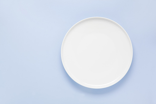 empty plate on a blue background - Фото, зображення