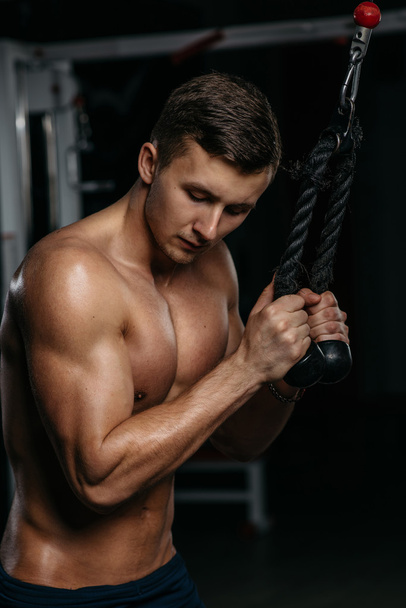 Young sports guy trains triceps - Φωτογραφία, εικόνα