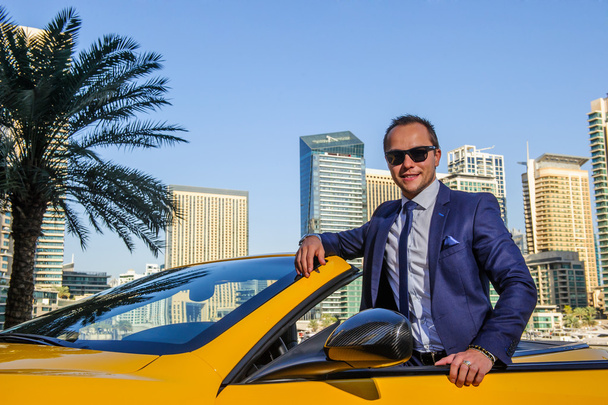 Succesvolle yang zakenman in gele cabrio auto - Foto, afbeelding