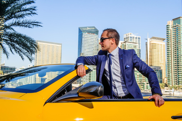 Succesvolle yang zakenman in gele cabrio auto - Foto, afbeelding