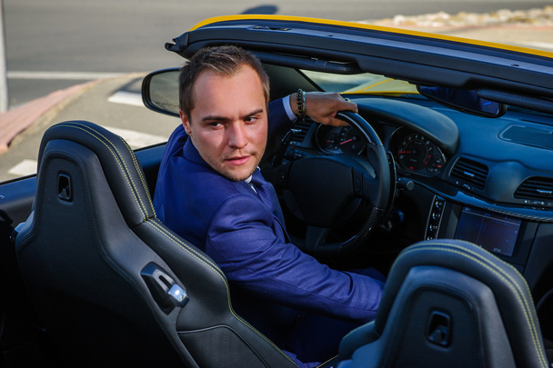 Successful yang businessman in yellow cabrio car. - Foto, Bild