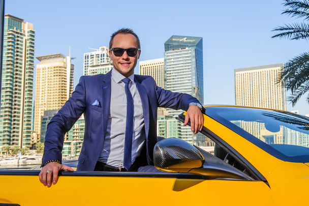 Succesvolle yang zakenman in gele cabrio auto. - Foto, afbeelding