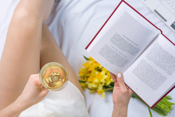 Frau mit einem Glas Wein im Bett - Foto, Bild