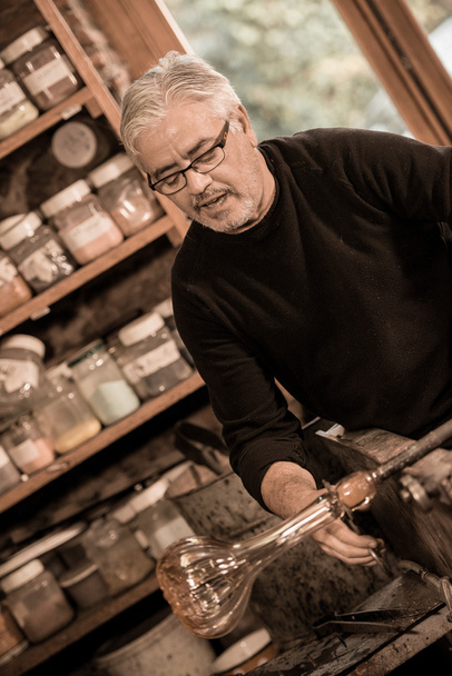 Glassblower forming molten glass in his worshop - Foto, immagini