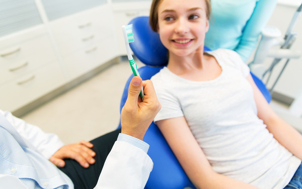 close up of dentist hand with toothbrush and girl - Photo, Image