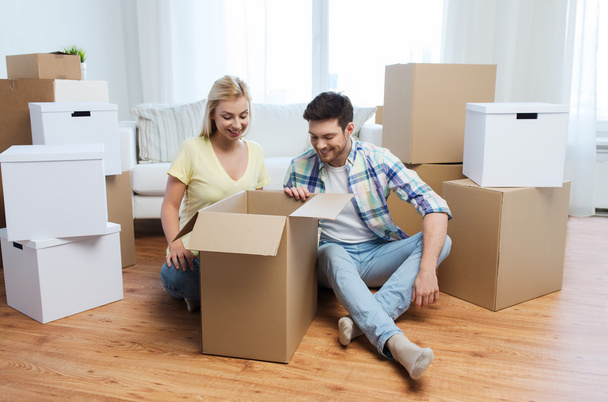 smiling couple with big boxes moving to new home - Fotoğraf, Görsel