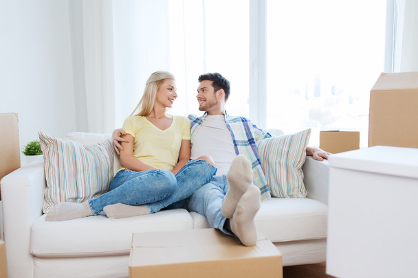 happy couple with big cardboard boxes at new home - Foto, immagini