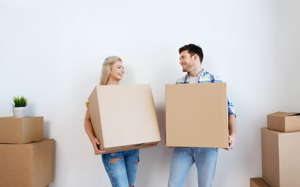 couple souriant avec de grandes boîtes déménageant dans une nouvelle maison
 - Photo, image