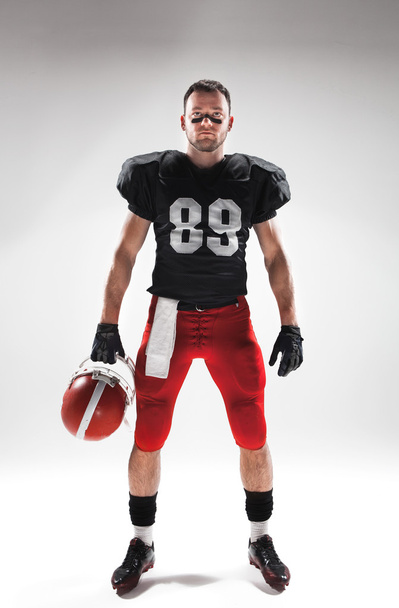 American football player posing with ball on white background - Fotó, kép