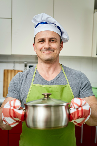 Cook holding a pot - Foto, Imagen
