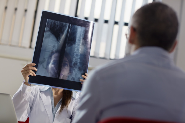 Ärztin arbeitet im Krankenhaus mit Patientin und Röntgenaufnahmen - Foto, Bild