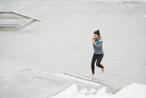 Woman running and climbing stairs - Foto, imagen