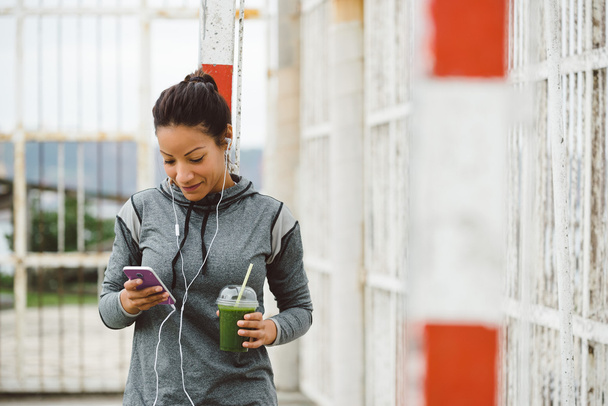 Urban fitness woman texting on her smarphone - Zdjęcie, obraz