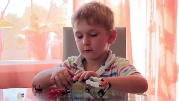 Junge Design-Maschine aus farbigen Spielzeugteilen - Filmmaterial, Video